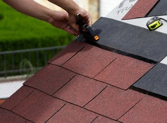 Roofing professional working on a residential roof repair in the Hialeah area